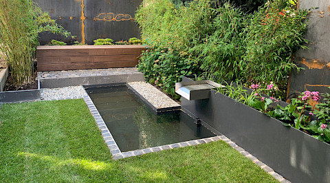 Kleiner Stadtgarten mit individuell gefertigten Metallelementen und Wasserbecken in Paderborn