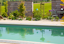 Pool mit Bepflanzung und Mauern als Sichtschutz in einem Garten in Lichtenau.
