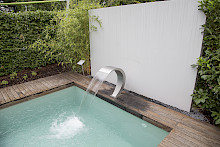 Ausstelllunggarten auf der Landesgartenschau in Bad Lippspringe mit Pool und Schwalldusche und einem umlaufenden Holzdeck.