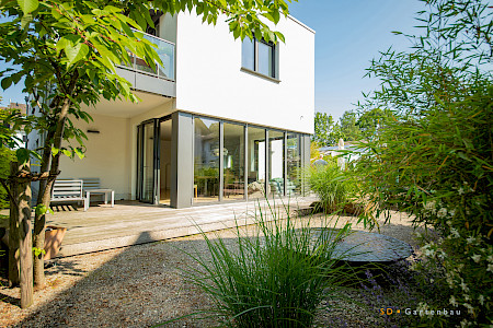 Stadtgarten in Paderborn mit Holzterrasse, Wasserschale aus Cortenstahl und Bepflanzung in wassergebundener Wegedecke.