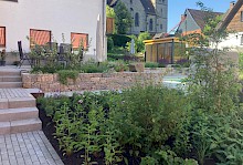 Terrasse mit angrezendem Weg aus Blockstufen und Pflaster in Beton, sowie einer Trockenmauer aus Muschelkalk.