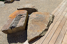 Holzterrasse in Paderborn mit eingelassenen Findlingen aus Grauwacke.