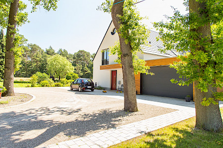 Hofeinfahrt mit modernem Haus in Delbrück aus wassergebundener Wegedecke und Weg aus Betonpflaster.
