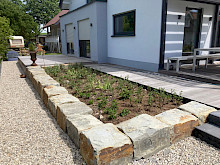 Kiesweg aus Lippekies mit angrezendem Hochbeet aus Natursteinquadern.