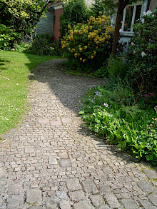 Eingang und Weg in einem Vorgarten in Paderbornaus Naturstein in unterschiedlichen Größen.