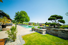 Poolgarten in Lichtenau mit Keramikplatten und Mauern aus Betonsteinen.