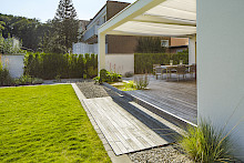 Modernes Einfamilienhaus mit großzügiger Holzterrasse und angrenzendem Rasen in Paderborn.