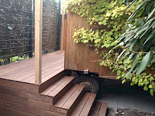 Alter Bauwagen in einem Privatgarten in Paderborn mit einer maßgefertigten Holztreppe sowie Holzdeck.