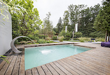 Pool mit Schwalldusche und umlaufenden Holzdeck im Mustergarten auf der Landesgartenschau in Bad Lippspringe.