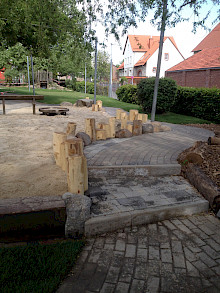 Einfassung eines Spielbereichs aus rustikalen Robinienhölzern in einem Kindergarten in Paderborn.