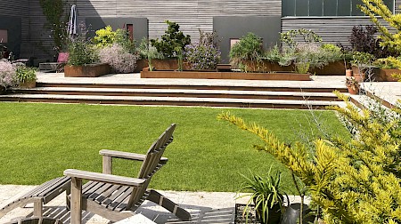 Eigens für den Garten geplante und maßgefertigte Treppenanlage sowie Hochbeete aus Cortenstahl.