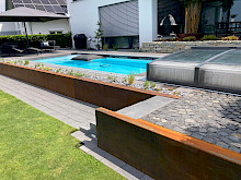 Poolgarten in Borchen mit Winkelsteinen, die mit Cortenstahl verblendet wurden.