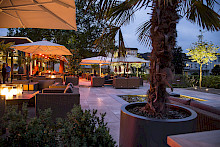 Abendstimmung einer Gastronomieterrasse in Bad Lippspringe, welche mit unterschiedlichen Leuchten beleuchtet ist.