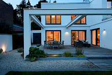 Beleuchtetes Wasserspiel auf der Terrasse eines modernen Einfamilienhauses in einem modern gestalteten Privatgarten in Paderborn.