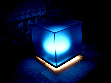 Beleuchtetes Kunstobjekt in Form eines blauen Würfels.