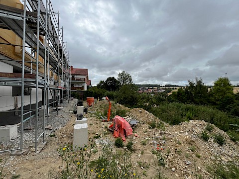 Haus im Rohbau mit angrenzendem Grundstück, dass noch nicht gestaltet ist und aufgemessen wird.