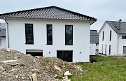 Haus nach der Fertigstellung mit unfertigem Garten und großem Erdhaufen.