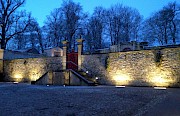 Historische Natursteinmauer mit Treppenanlage und Tor am Abend mit Beleuchtung im Kloster Dalheim.