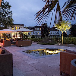 Gastronomieterrasse am Abend mit Beleuchtung und Wasserspiel in Bad Lippspringe.